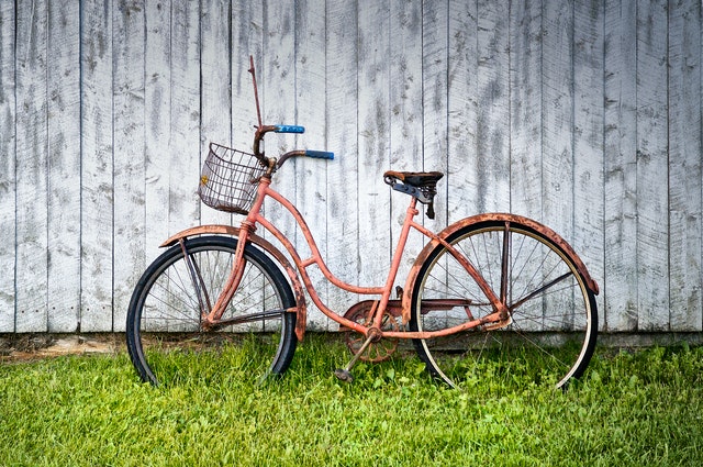 Vélo rouge posé contre bardage bois